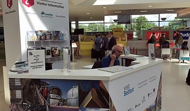 Receptionist on the phone at the visitor information kiosk.