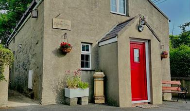 Exterior of cottage with summer seat