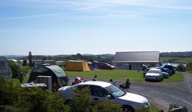 Image is of campsite with people sitting around