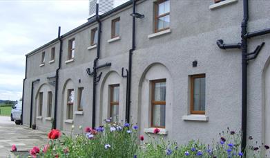 Image is of front of property with flower beds