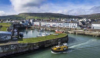 Curiosity boat leaving historical Carnlough harbour 