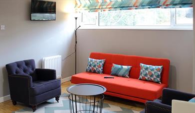 living area with orange sofa and 2 navy armchairs