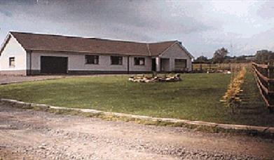 Driveway of a country Bungalow BnB with a large front lawn.