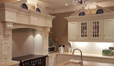 Modern Kitchen with range cooker, cream cabinets and sink in the island