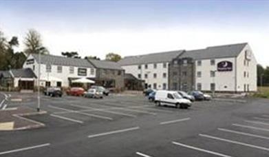 Image shows front of hotel and car parking spaces