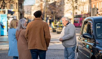 Billy Scott greets his tour group for the Belfast Black Cab Tour