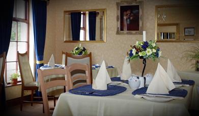 Image shows breakfast room with tables and chairs