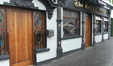 A white building with ornate black features and a wooden door