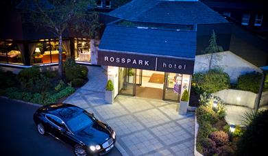 Night time exterior of entrance to Ross Park Hotel in Kells with car parked outside