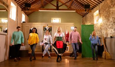 Group in a row with the instructor in front being taught Irish dancing as part of the Dancing at the Crossroads experience