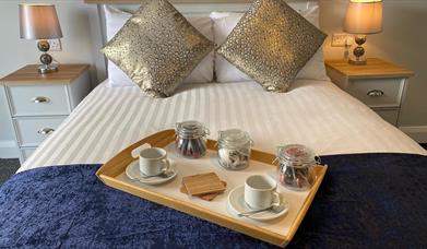 Image show breakfast tray on double bed in guest room