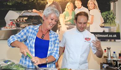 Image shows directing a lady who is cooking