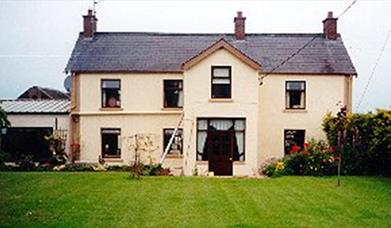 A large two-story lodge with a lawn.