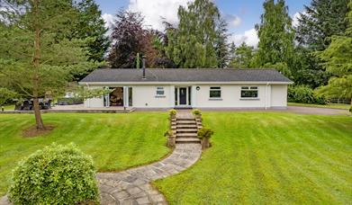Photograph of front of house and green lawn