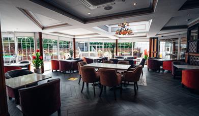 An image showing a dining room with a window wall out to an outside dining area.