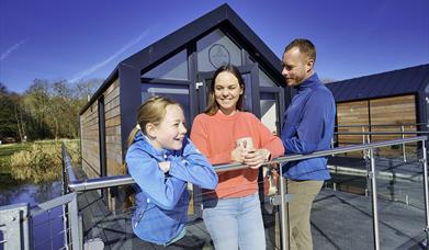 A family outside the house boat glamping pods at Ballyronan Marina