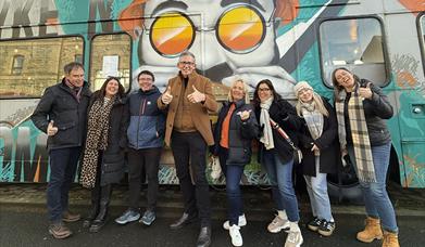 Group shot outside of pyke n pommes double decker bus restaurant
