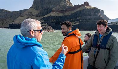 Guide/skipper of the boat talking to a group enjoying the Giant Shipwrecks of the North Coast experience