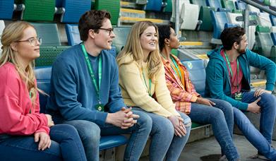 Group in the football stands enjoying a behind the scenes guided tour of Windsor Park with the Irish Football Association