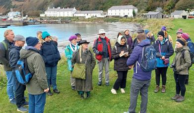 people gather outside on Rathlin Island listening to a tour guide