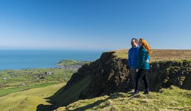 Walkers looking over cliff top at Sallagh Braes