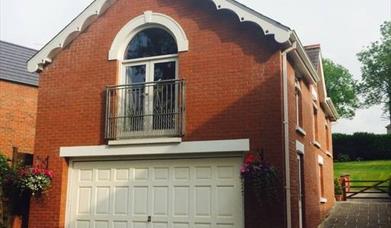 Image shows upstairs apartment patio doors and garage underneath