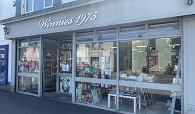 Grey exterior of Winnies 1975 with large window displays