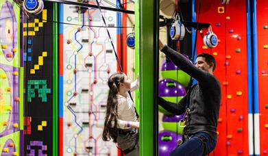 Young Girl and Dad on Face to Face Climbing Wall