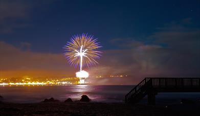 Image shows fireworks lighting up the sky above Ballycastle Beach