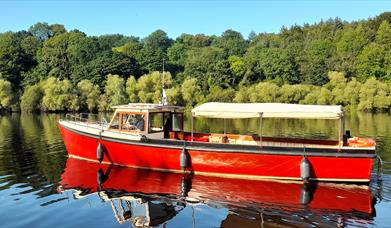 MV Kingfisher boat on the river with Mountsande in  background.