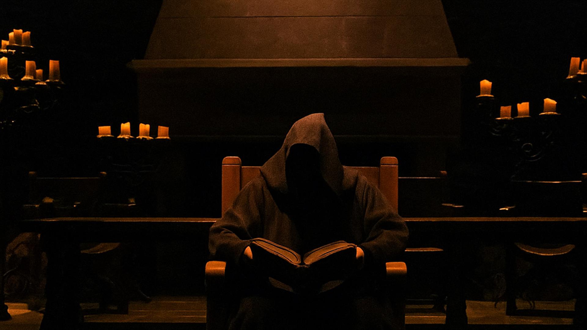 Hooded figure storyteller sitting in Winterfell Hall