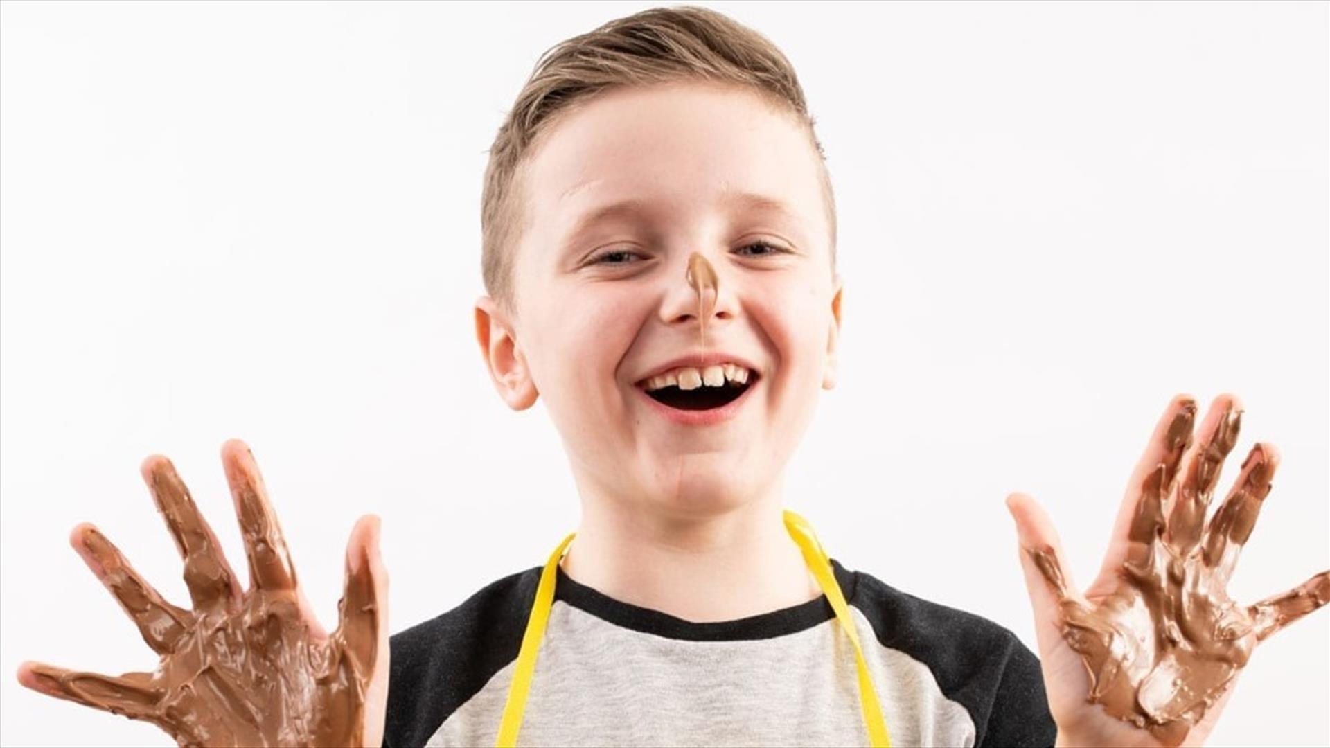 boy with hands covered in melted chocolate