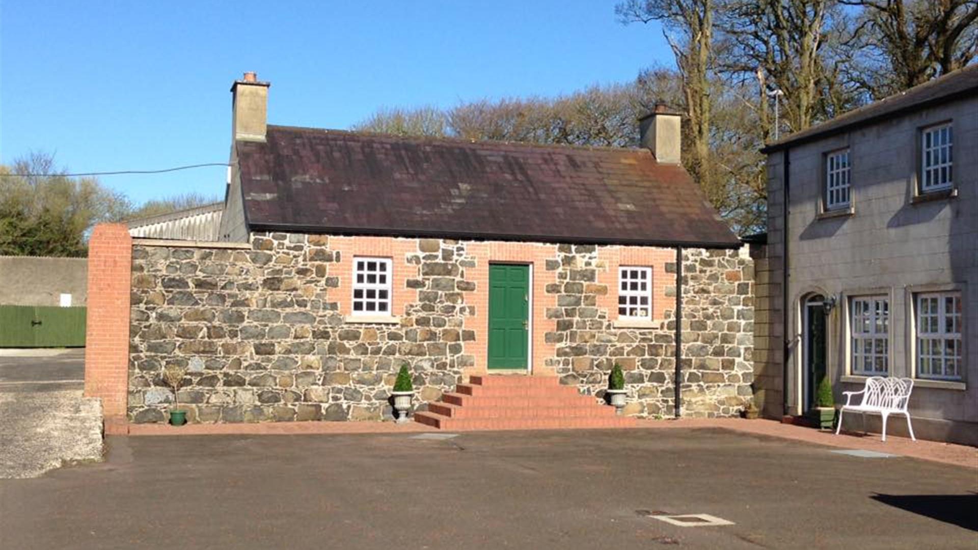 The exterior of a cottage with a green door