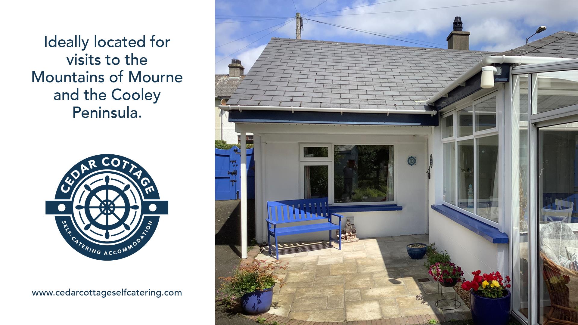 A view of the exterior of Cedar Cottage. A white cottage with blue accents.