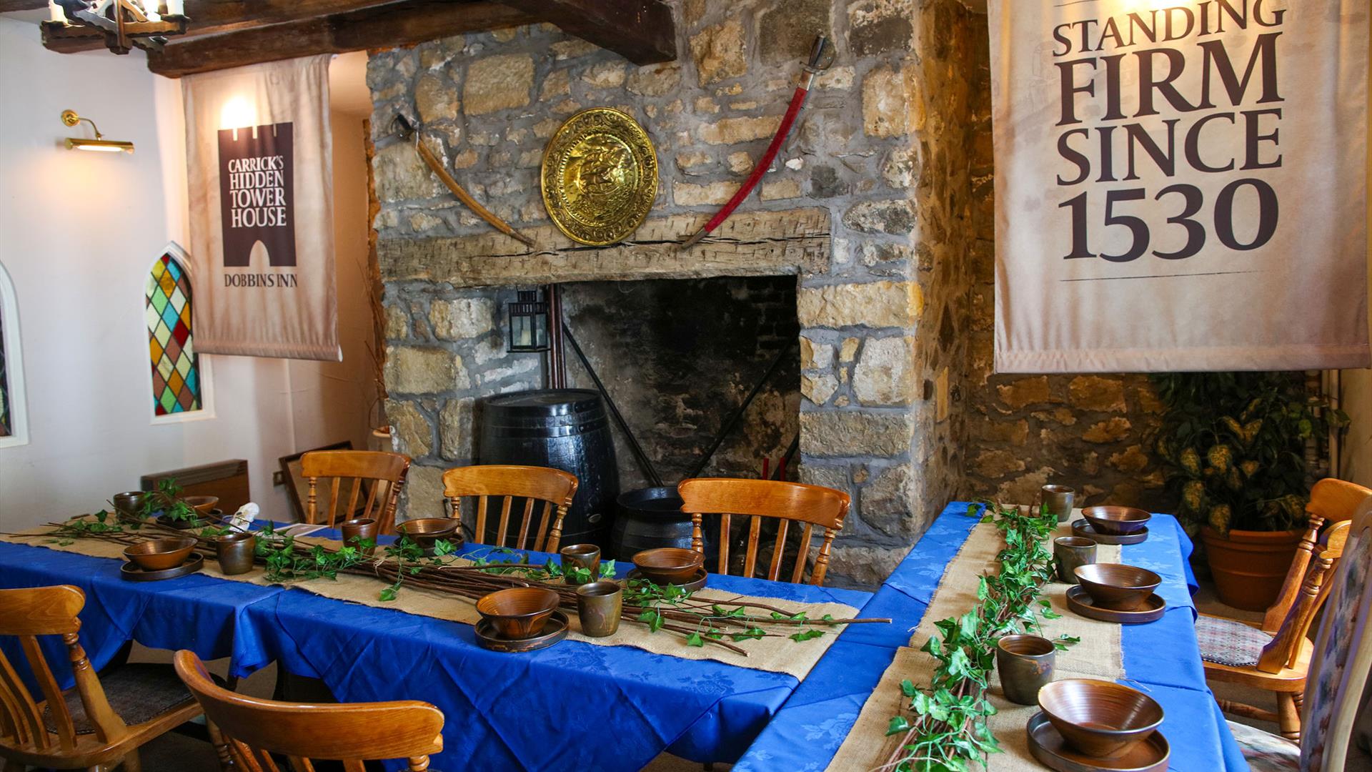 Room set up for Dobbins dining experiece as part of Dobbins Dander and Dine with seats and long tables in front of a large fireplace.