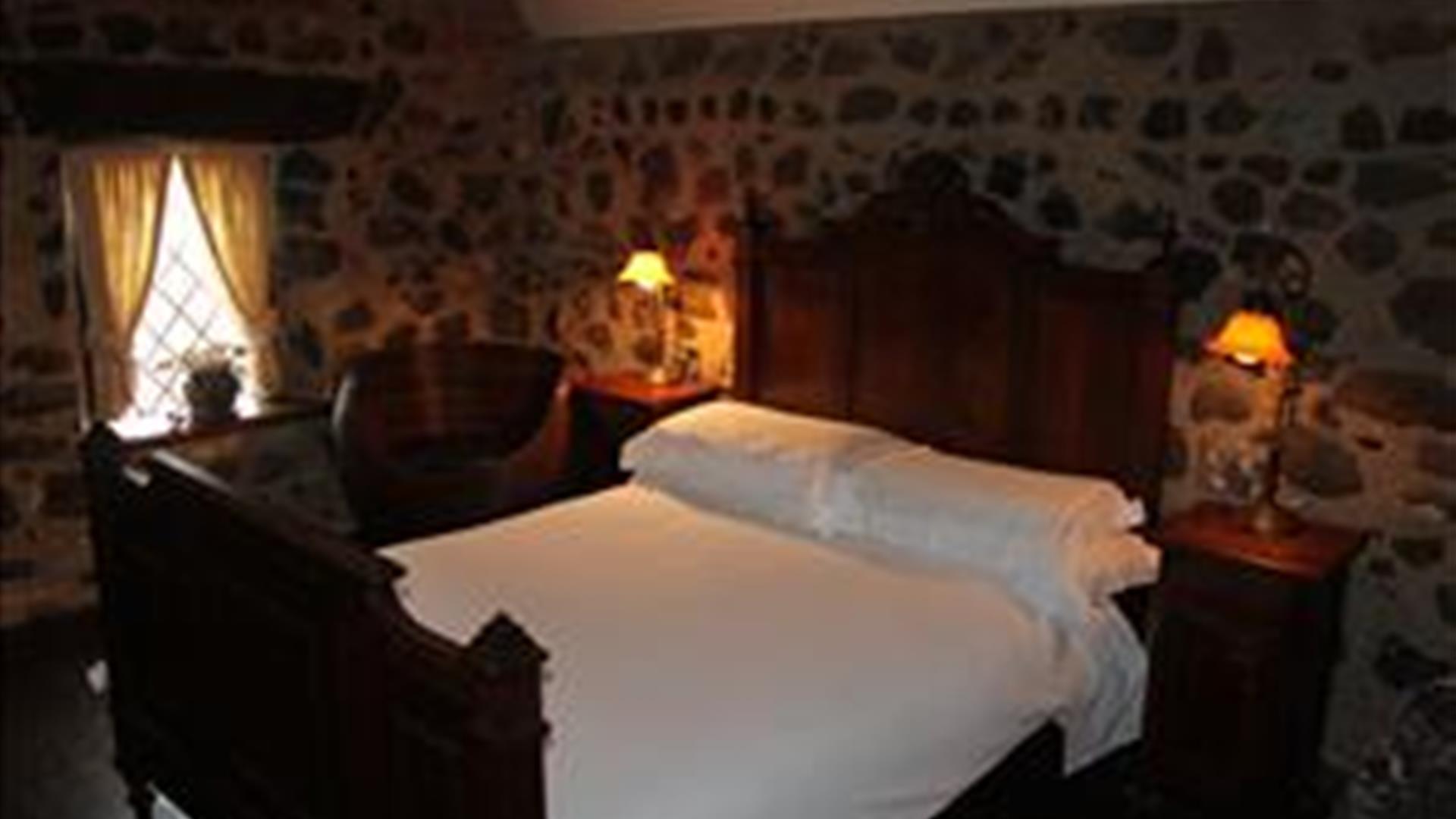 Image shows double bedroom with side tables and lamps