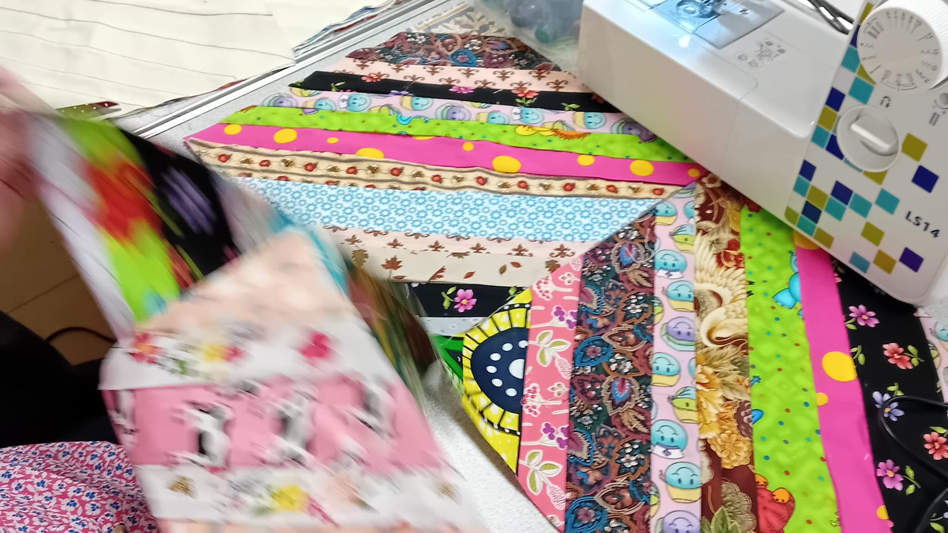 Sewing machine and patchwork quilt in progress at Midtown Makers workshop