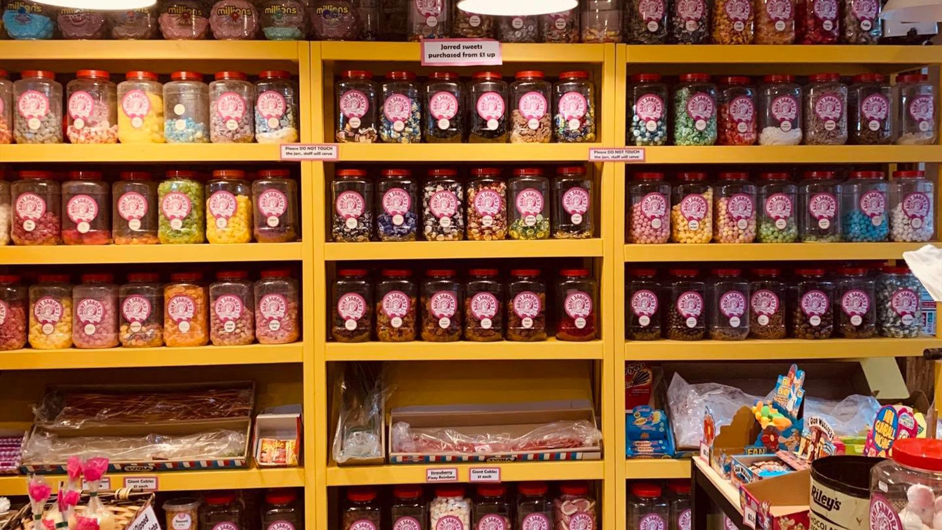 Shelves filled with jars of dozens of different home made sweets.