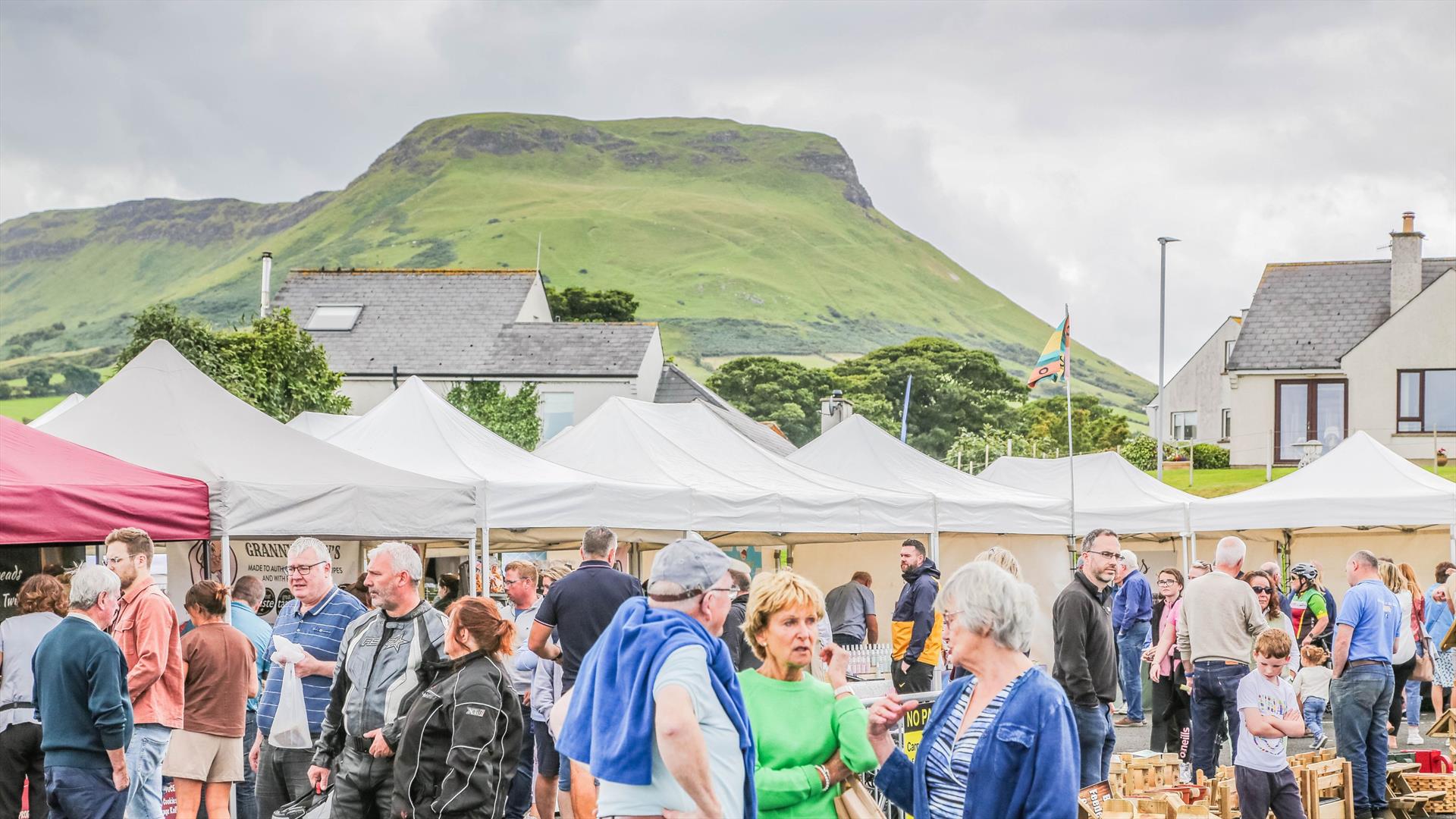 People browsing busy outdoor market stalls