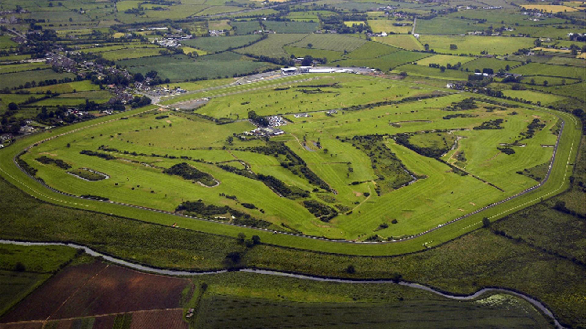 Shows aerial image of the whole golf course and surrounding countryside