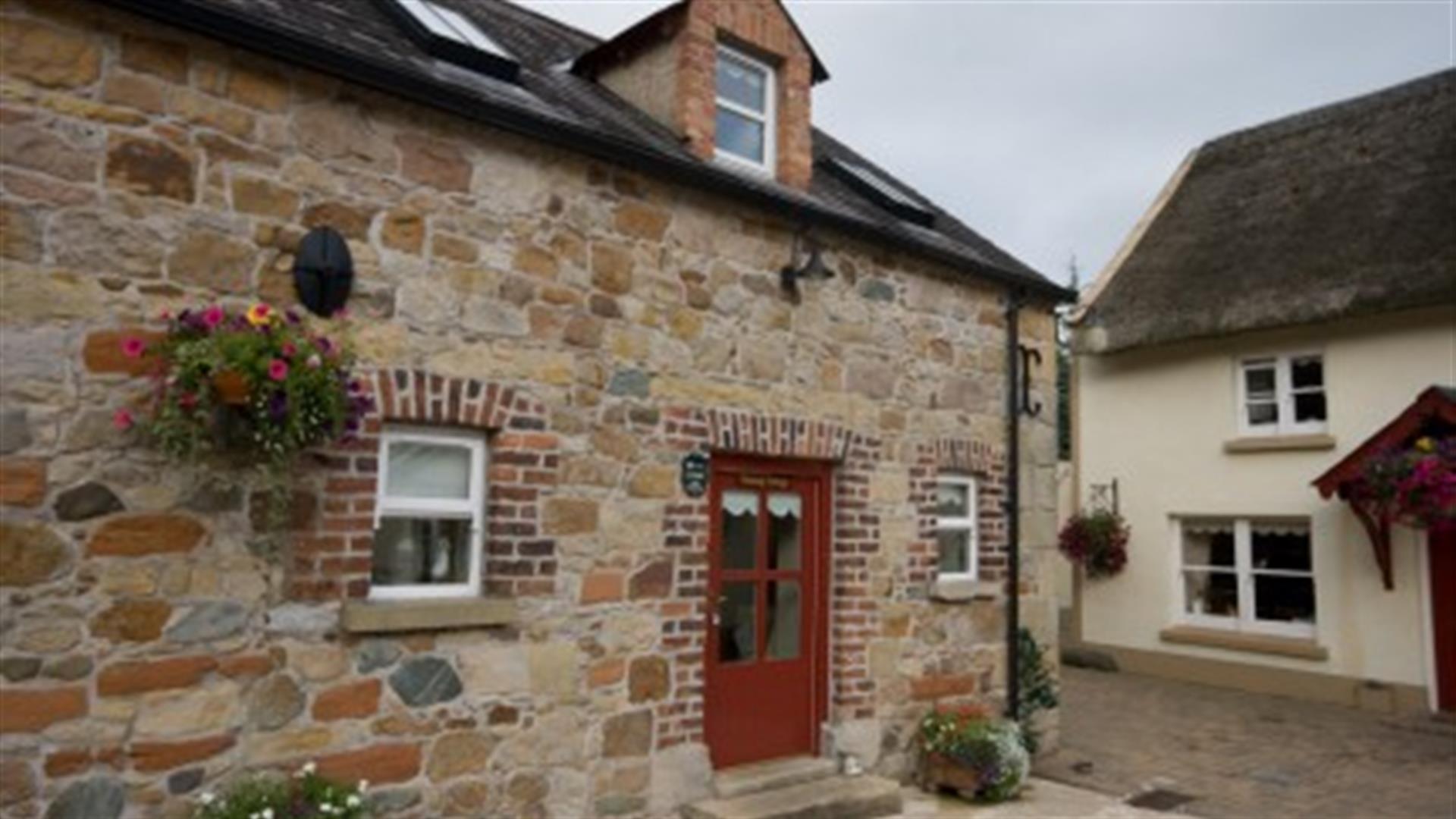 entrance to cottage with red door and stone walls