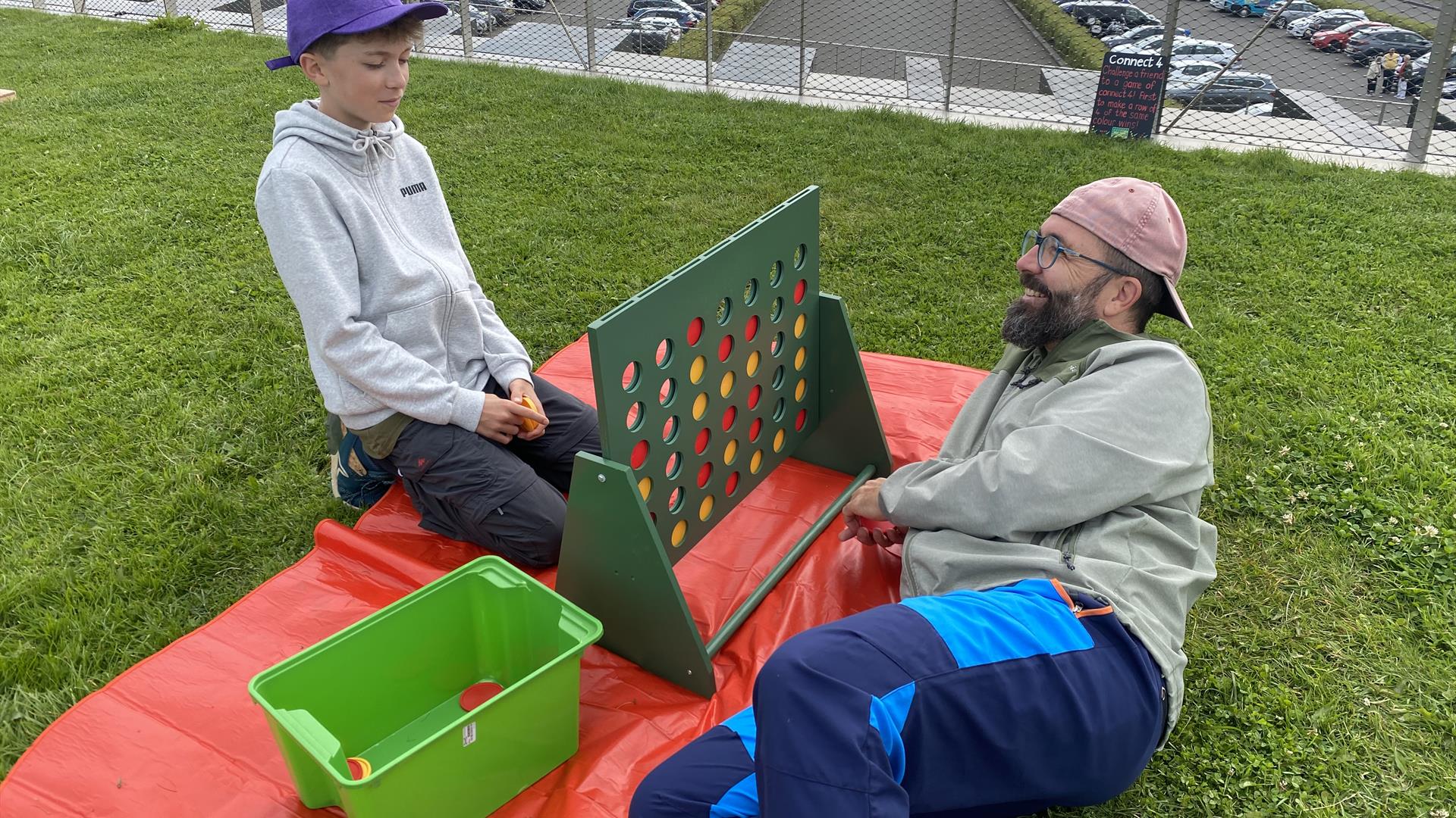 Two visitors enjoying a game of GIANT Connect 4 on the roof of the Giant's Causeway Visitor Centre