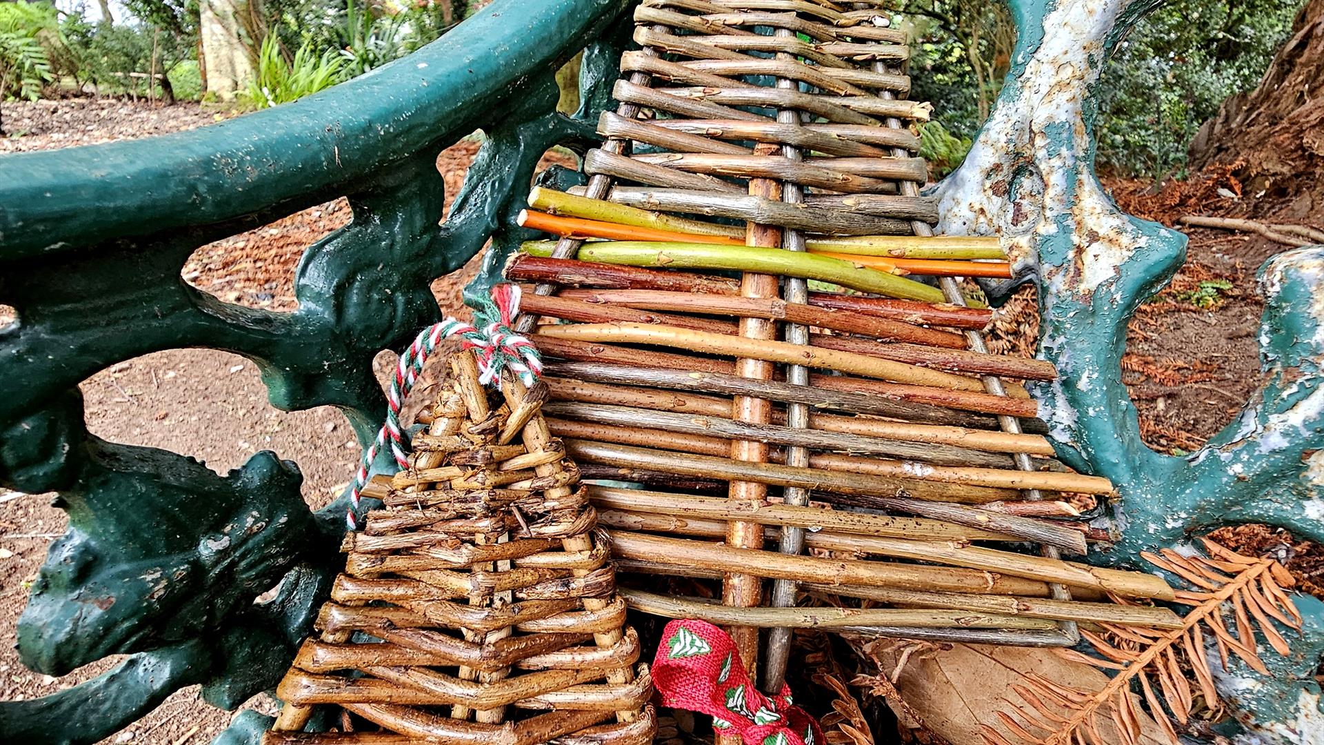 WILLOW CHRISTMAS TREES SITTING ON A GARDEN BENCH