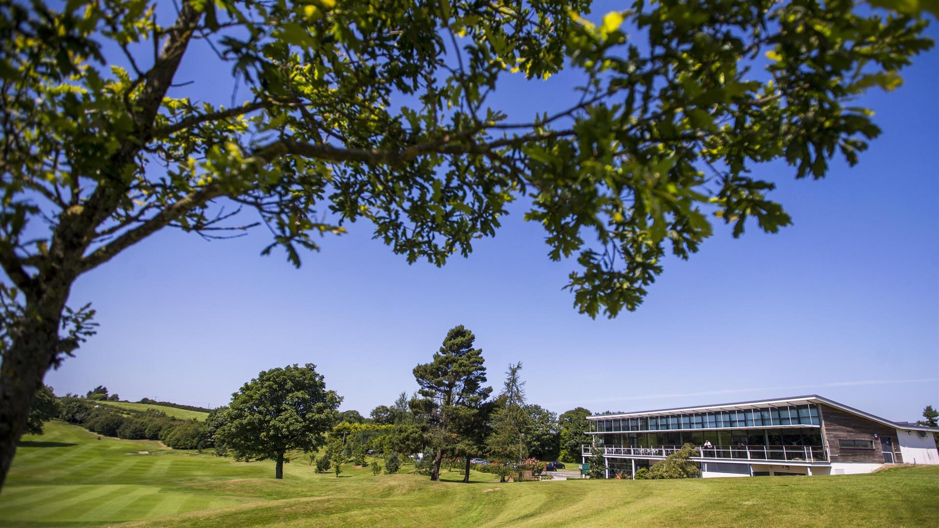 Image shows main building with golf course and trees