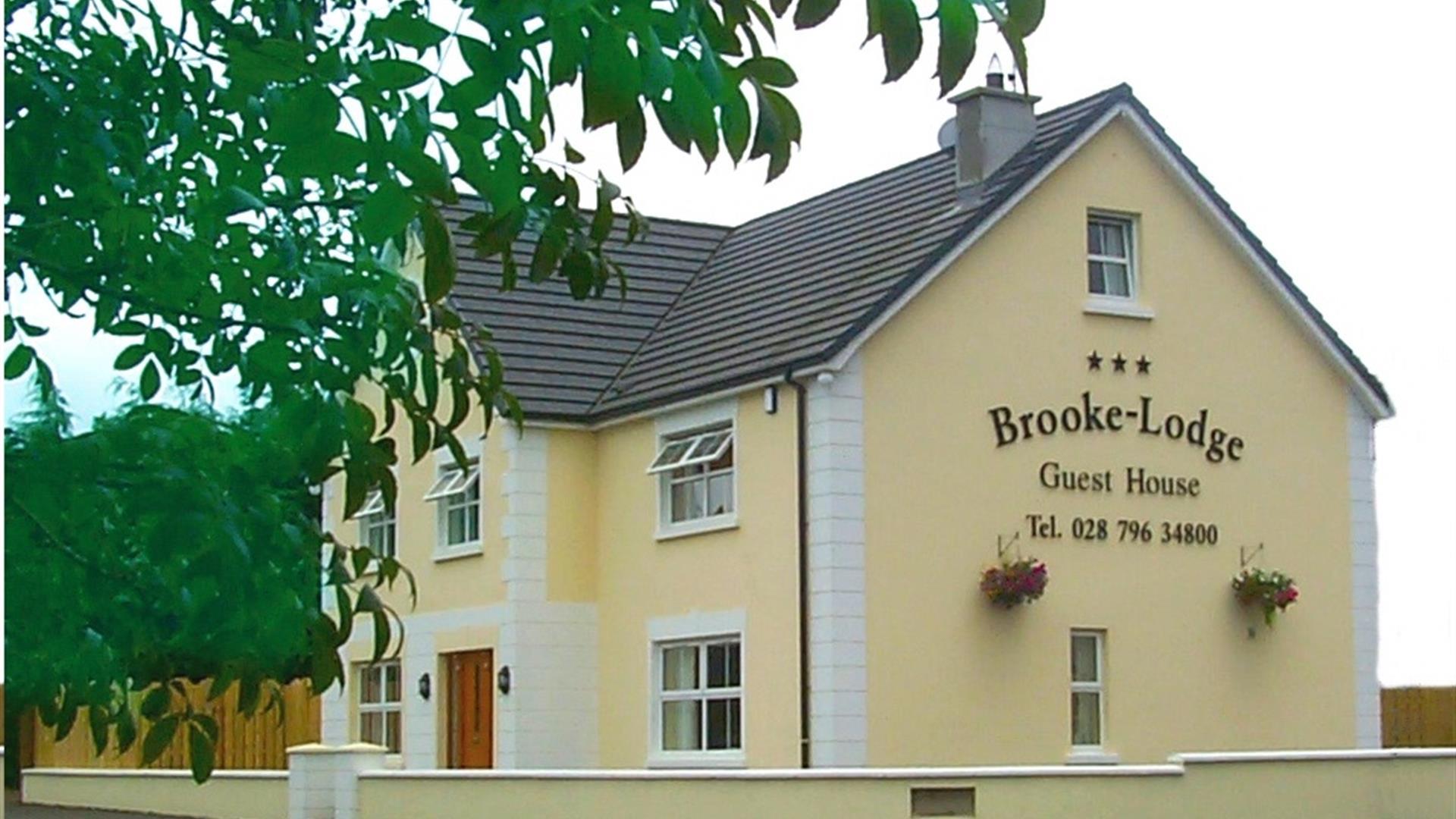 Outside of Brookelodge Guest House.  Yellow painted 2 storey detached house with wooden front door