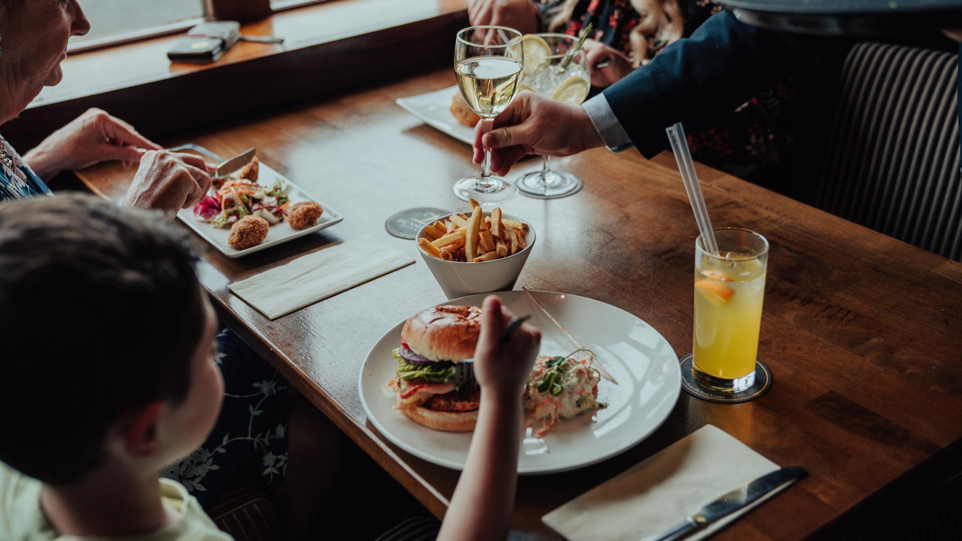 A family enjoying dinner and being served wine.