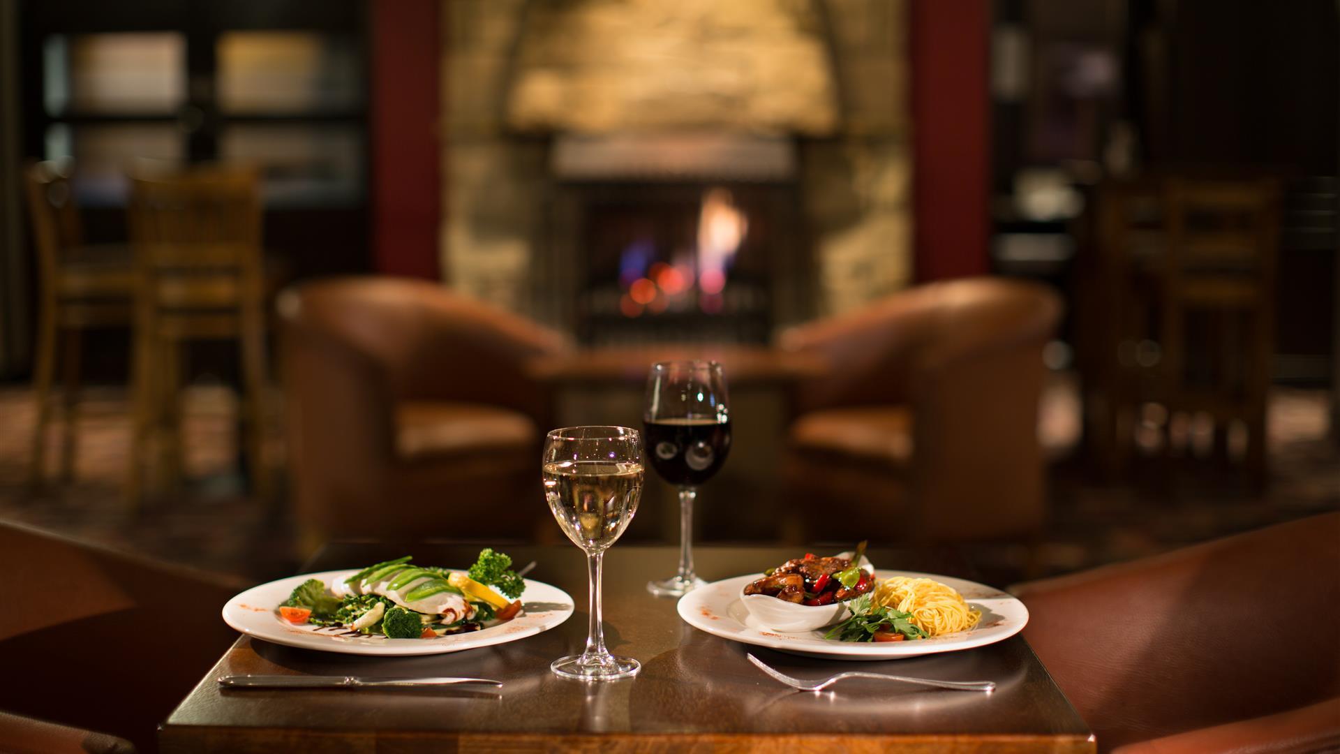 Table set for two with meals and glasses of wine