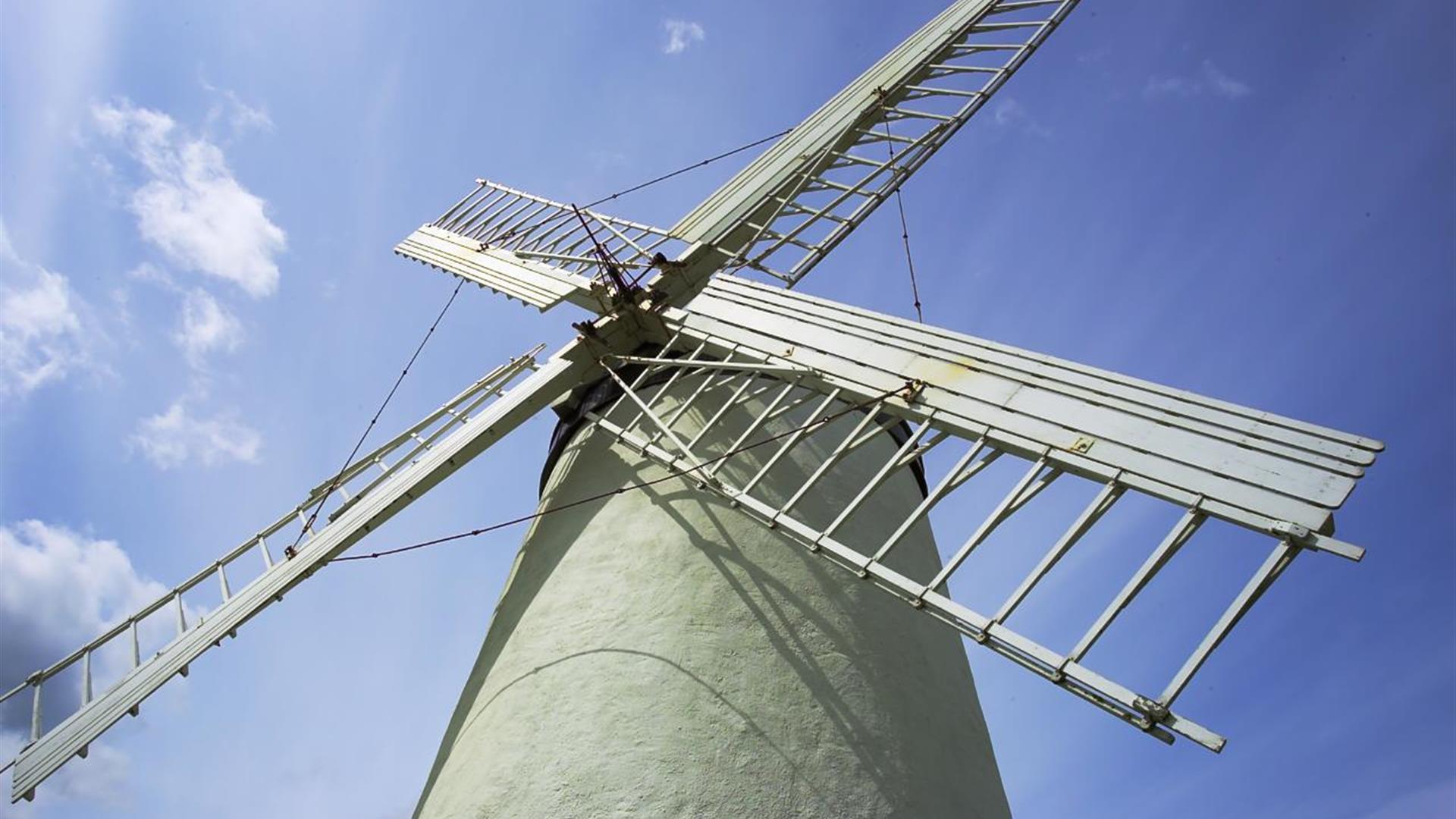 a photograph looking up at a windmill with a blue sky in the background