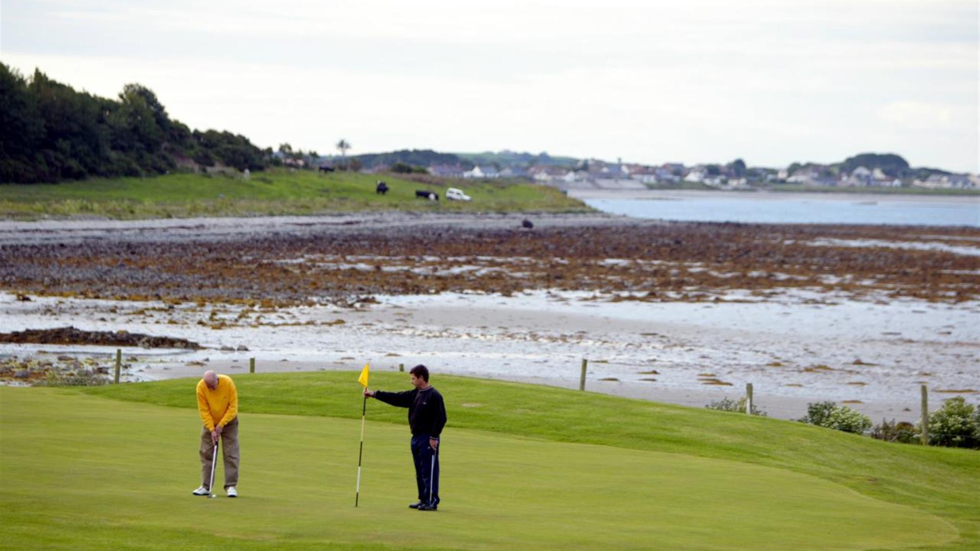 Photo of two golfers in play with stunning scenery to the background