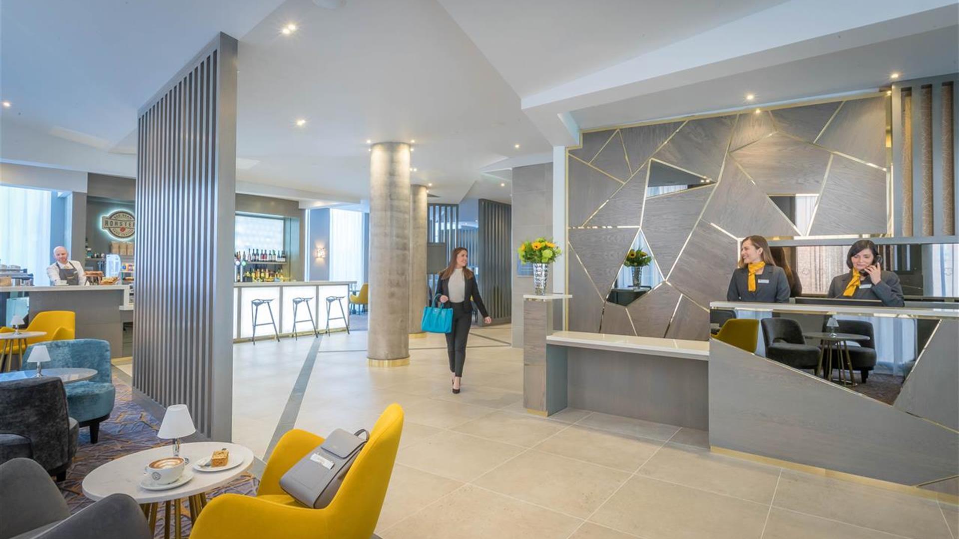 A woman walking through reception while receptionists work.